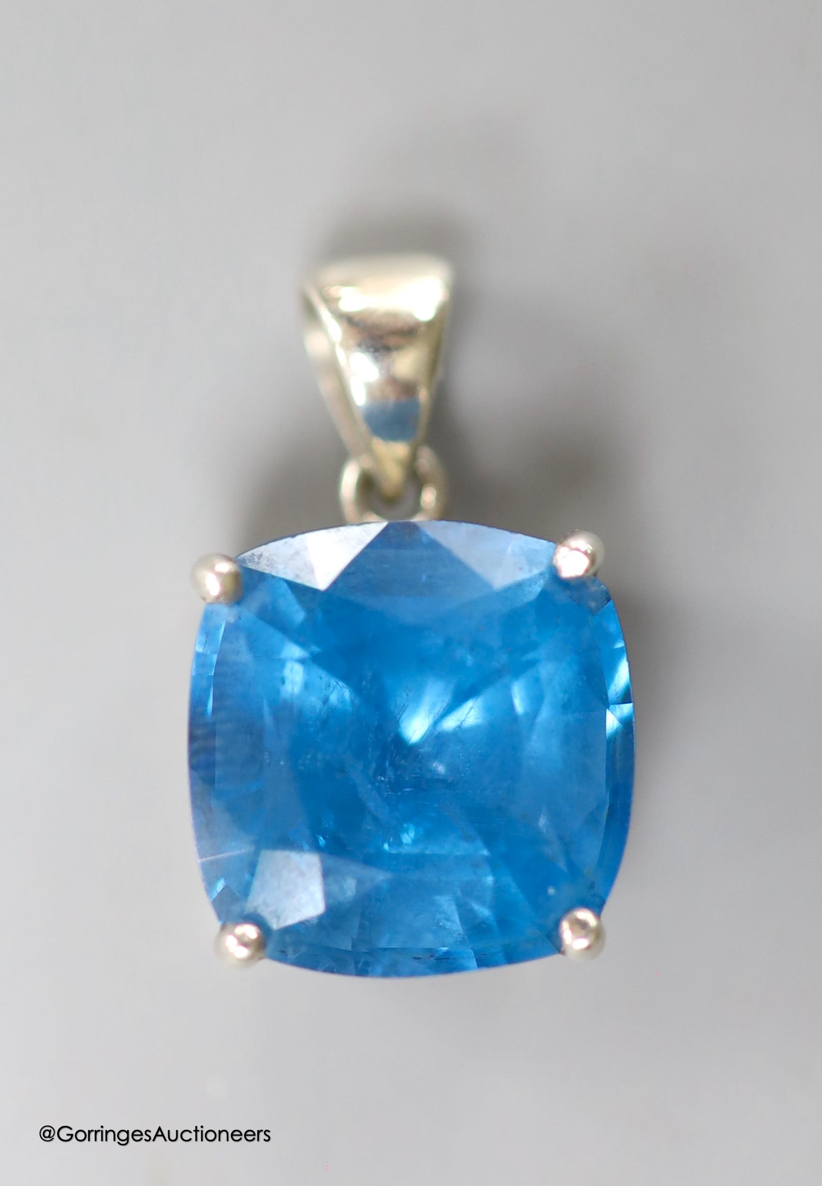 A white metal mounted square cushion cut blue topaz pendant